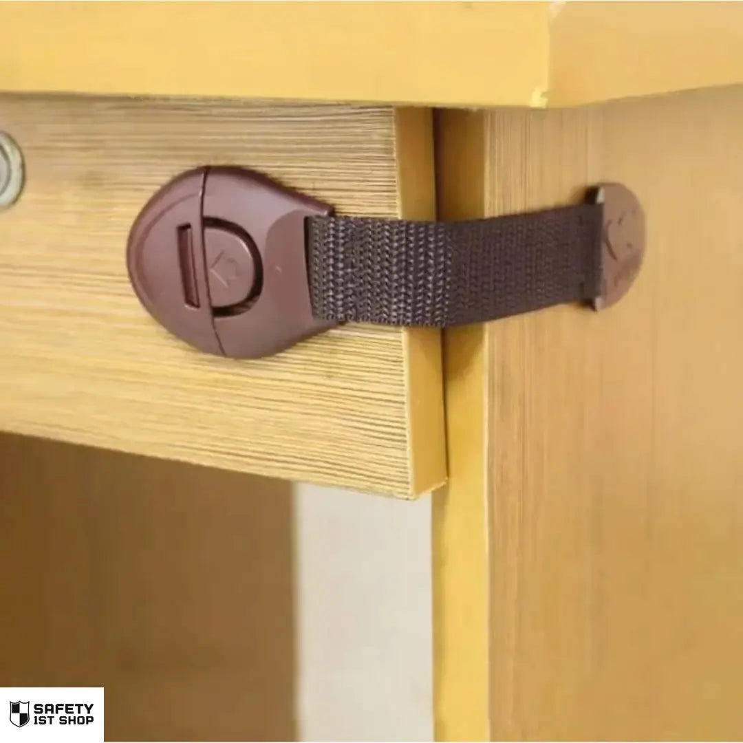 Brown child safety lock mounted on cabinet - babyproof latch in action