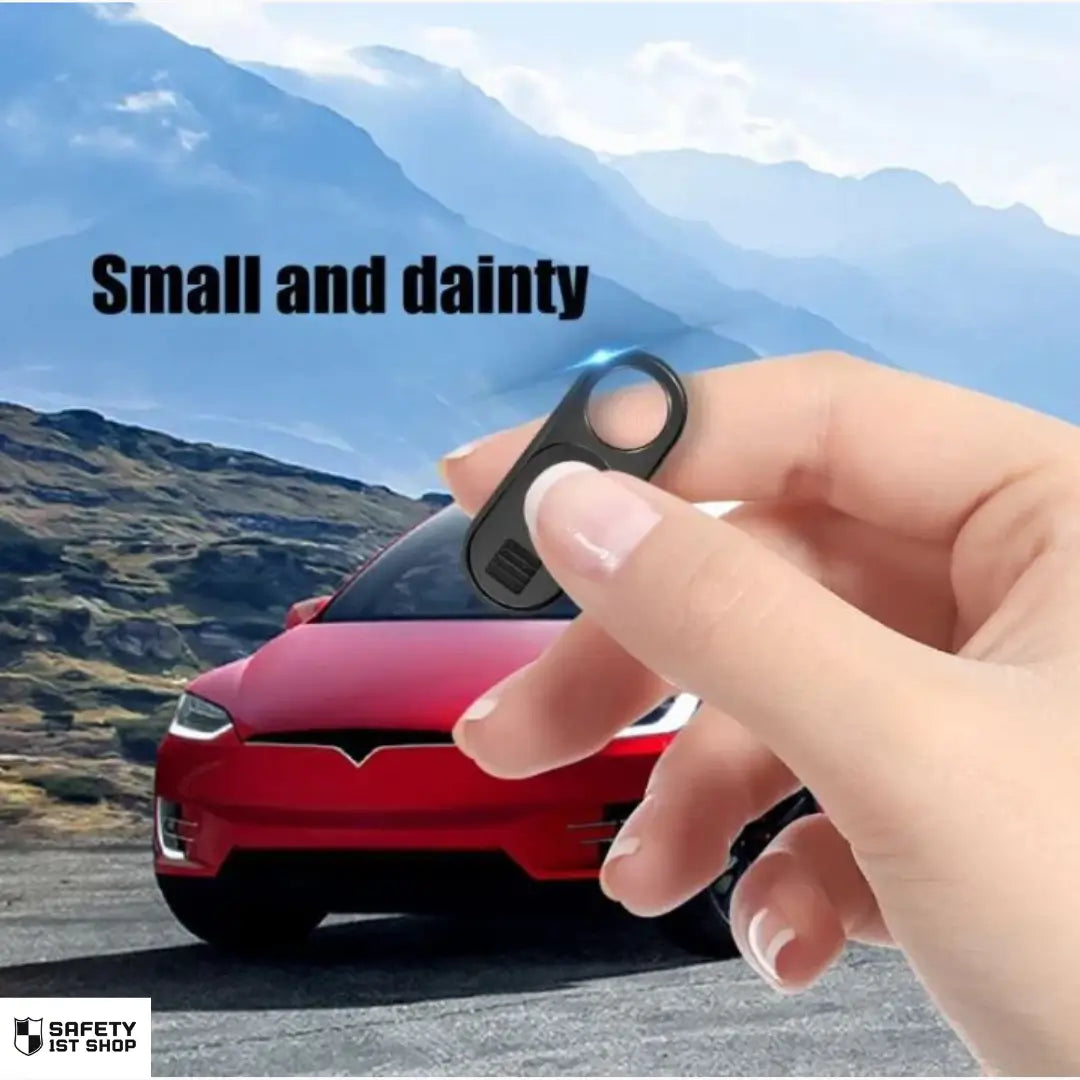 Hand holding small webcam privacy cover with parked Tesla and mountain landscape – product size and elegance highlighted