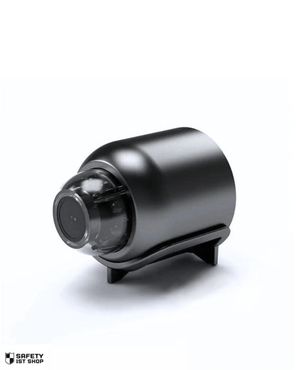 High-gloss black mini surveillance camera centered on a clean white background, shown in large scale for premium visual impact. Branded with subtle logo at bottom left.