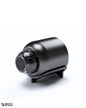 High-gloss black mini surveillance camera centered on a clean white background, shown in large scale for premium visual impact. Branded with subtle logo at bottom left.