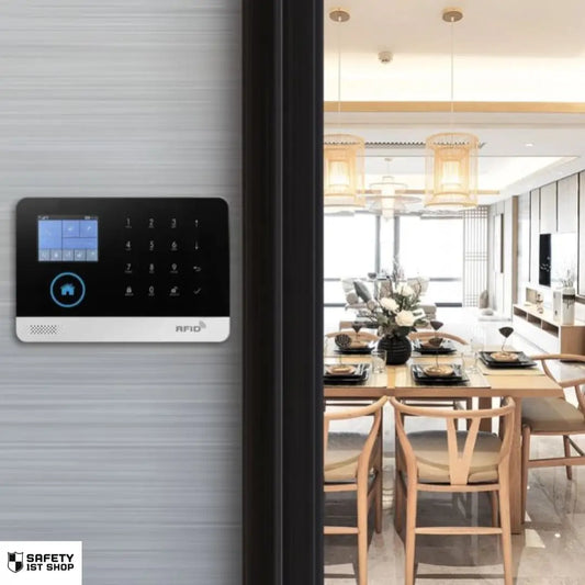 Wall-mounted black smart security device in a luxury living and dining room – blending elegant design with discreet protection.